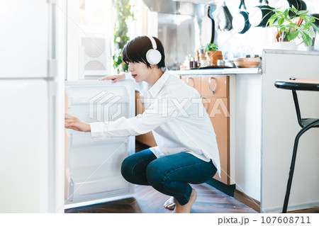 冷蔵庫を開ける女性ポートレイト 107608711