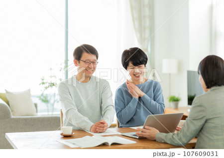 商談をするシニア夫婦とビジネスウーマン 107609031