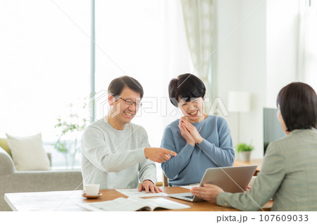 商談をするシニア夫婦とビジネスウーマン 107609033