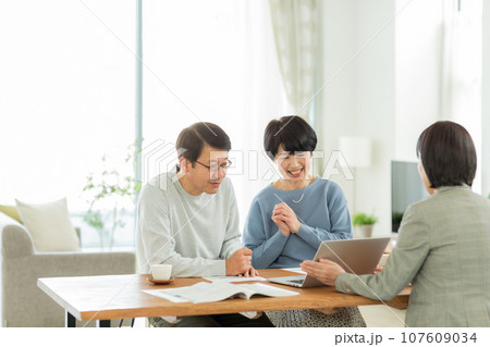 商談をするシニア夫婦とビジネスウーマン 商談をするシニア夫婦とビジネスウーマン 107609034