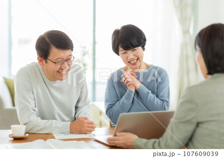 商談をするシニア夫婦とビジネスウーマン 107609039