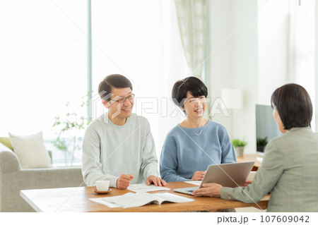 商談をするシニア夫婦とビジネスウーマン 商談をするシニア夫婦とビジネスウーマン 107609042