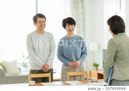 商談をするシニア夫婦とビジネスウーマン 107609048