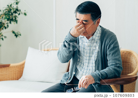 目の疲れを感じるシニアの男性 107609803