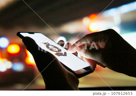 夜の街角にてスマホでサイバー犯罪を企む 107612653