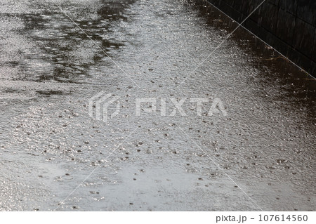 道路の水しぶき 雨降りで地面の水たまりにできた水紋 波紋 107614560