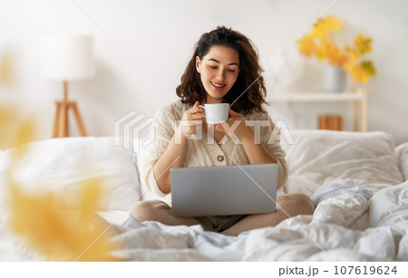 woman wearing warm clothes is using laptop 107619624
