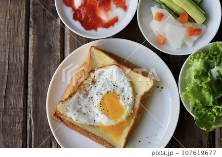 朝ごはん　目玉焼きのせトーストとヨーグルトと野菜 107619677