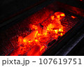 熱を帯びて赤くなる炭 107619751
