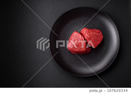 Fresh juicy raw beef medallions with salt and spices 107620334