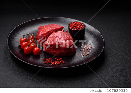 Fresh juicy raw beef medallions with salt and spices 107620336