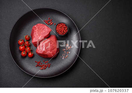 Fresh juicy raw beef medallions with salt and spices Fresh juicy raw beef medallions with salt and spices 107620337