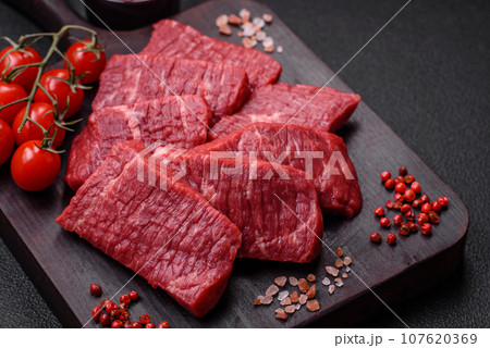Fresh juicy raw beef slices with salt and spices Fresh juicy raw beef slices with salt and spices 107620369
