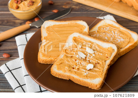 Peanut butter sandwiches or toasts on light table background.Breakfast. Vegetarian food. American cuisine top view vith copy space Peanut butter sandwiches or toasts on light table background.Breakfast. Vegetarian food. American cuisine top view vith copy space 107621809