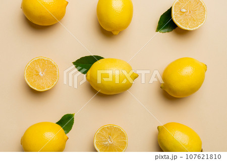 Many fresh ripe lemons as colored background, top view. Elegant background of lemon and lemon slices Top view flat lay Many fresh ripe lemons as colored background, top view. Elegant background of lemon and lemon slices Top view flat lay 107621810