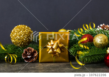 New Year Christmas mood, gift box, branches of a christmas tree, New Year decorations on a colored background New Year Christmas mood, gift box, branches of a christmas tree, New Year decorations on a colored background 107622206