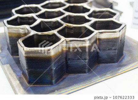 3d printed metal model close-up. Model printed on a 3D printer made of metal. Three-dimensional metal object created by a 3d printer from metal. 3D printing additive modeling manufacturing technology 3d printed metal model close-up. Model printed on a 3D printer made of metal. Three-dimensional metal object created by a 3d printer from metal. 3D printing additive modeling manufacturing technology 107622333