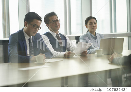 through-the-glass shot of a team of asian HR people interviewing candidate in office through-the-glass shot of a team of asian HR people interviewing candidate in office 107622424