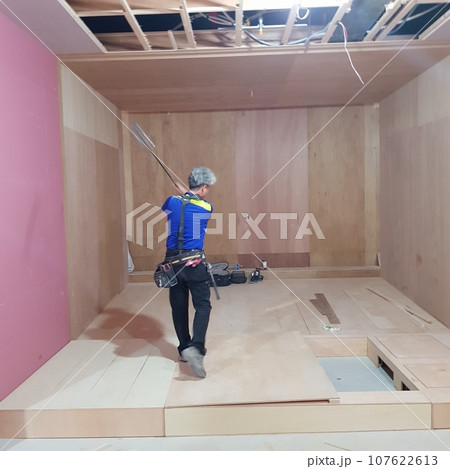 worker installing tiles on a floor worker installing tiles on a floor 107622613