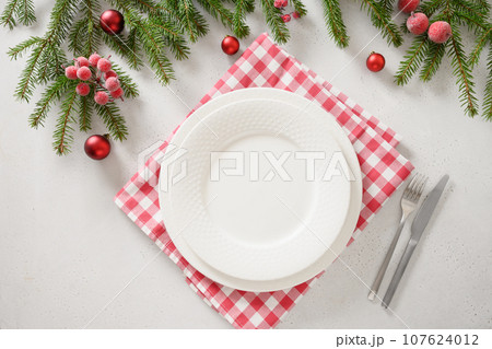 Christmas table setting with elegant red decorations on white background. Christmas table setting with elegant red decorations on white background. 107624012