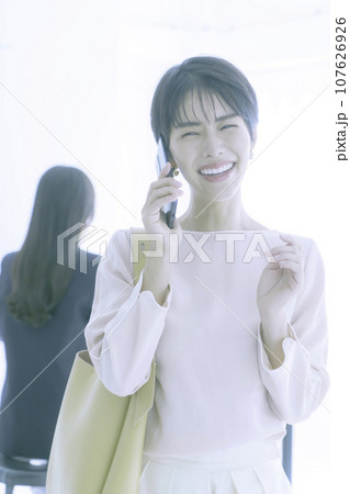 スマホで会話する笑顔の若い女性のポートレート 縦位置 スマホで会話する笑顔の若い女性のポートレート 縦位置 107626926