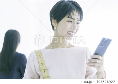スマホを見る笑顔の若い女性のポートレート 107626927