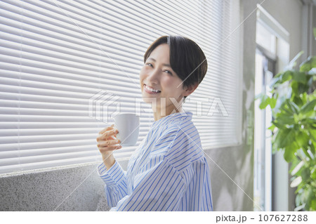 リラックスしてコーヒーを飲むミドル女性 リラックスしてコーヒーを飲むミドル女性 107627288