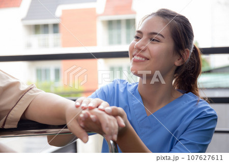 Caregiver asian woman care elderly sitting on wheelchair, consoling for encourage. Caregiver asian woman care elderly sitting on wheelchair, consoling for encourage. 107627611