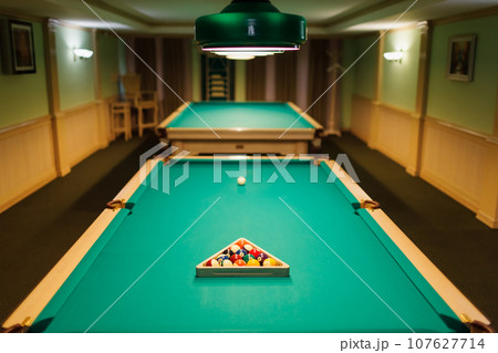 Billiard accessories balls and cue on a billiard table room 107627714