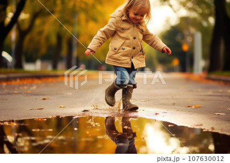 Adorable Child Splashing in a Puddle 107630012