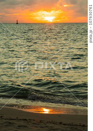 夕日に照らされる砂浜 107630761