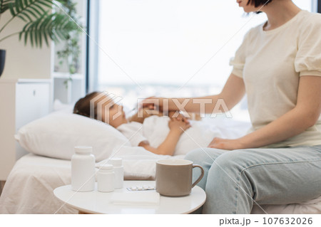 Mother using medical supplies on table for caring ill kid Mother using medical supplies on table for caring ill kid 107632026