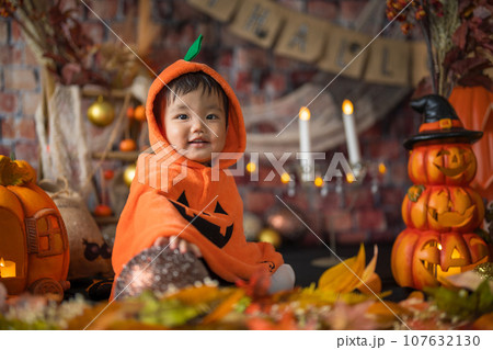 10月にハロウィンのフォトセットに囲まれて楽しそうな笑顔を見せる生後11か月の赤ちゃん 10月にハロウィンのフォトセットに囲まれて楽しそうな笑顔を見せる生後11か月の赤ちゃん 107632130