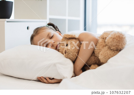 Cute ill girl sleeping sweet with teddy bear at home 107632207