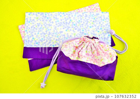 黄緑のカーペットの上の手作りのピンクと紫のミモザの花柄のお弁当用巾着と規定サイズのンチョンマット 黄緑のカーペットの上の手作りのピンクと紫のミモザの花柄のお弁当用巾着と規定サイズのンチョンマット 107632352