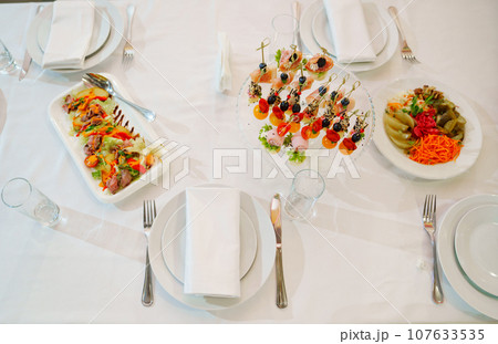 White round plate with serving napkin on table.  107633535