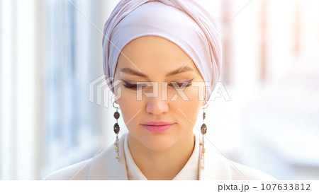 Muslim businesswoman in silver hijab looks smilingly Muslim businesswoman in silver hijab looks smilingly 107633812