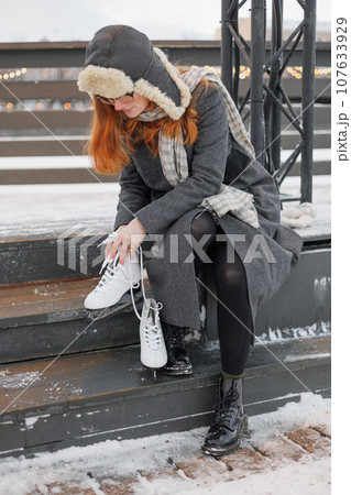 young European woman in winter clothes is skating young European woman in winter clothes is skating 107633929