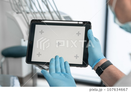 Chroma key effect green screen for tracking on electronic tablet in dental clinic dentist showing hand and showing on screen to patient in dental chair at appointment and consultation 107634667