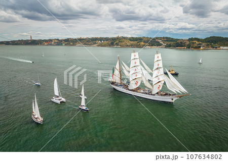 Aerial drone view of tall ships with sails sailing in Tagus river towards the Atlantic ocean in Lisbon, Portugal 107634802