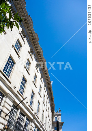 真っ青な快晴の空の下のリージェントストリートに並ぶ湾曲した歴史的な石造りの建物　ロンドンの街並み 107635458