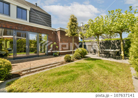an outside area with grass, bushes, and trees in front of a house that has been built for sale an outside area with grass, bushes, and trees in front of a house that has been built for sale 107637141