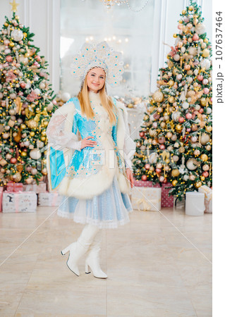 Snow Maiden in costume with short skirt and kokoshnik. room with christmas tree. 107637464