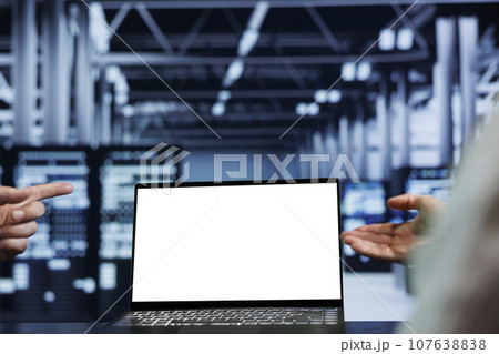Close up shot of mock up laptop used by competent technician in data center using server rigs to deliver massive computing power, control network resources, process and store datasets 107638838
