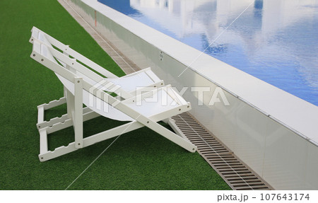 white beach deck canvas chair bed longue on the green grass white beach deck canvas chair bed longue on the green grass 107643174