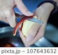 woman hand is cleaning red apple in bucket of water, closed up shot 107643632
