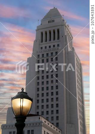 Los Angeles City Hall at dusk with vintage antique post style street light with blue sky and colorful wispy clouds. High quality photo 107643891