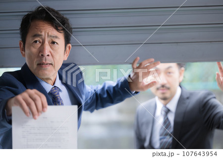 税務調査や逮捕状を持っている刑事のようなイメージ 税務調査や逮捕状を持っている刑事のようなイメージ 107643954