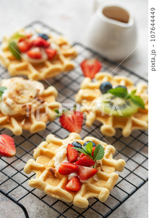 Freshly baked waffles with strawberries and blueberries Freshly baked waffles with strawberries and blueberries 107644449