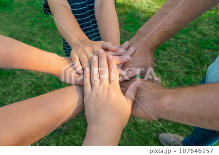 Joined hands as a team. Business teamwork. Close up group of multiracial friends meeting join hands together. Diversity people. Partnership volunteer community. Diverse multiethnic Partners. Top View Joined hands as a team. Business teamwork. Close up group of multiracial friends meeting join hands together. Diversity people. Partnership volunteer community. Diverse multiethnic Partners. Top View 107646157